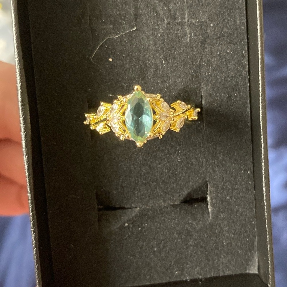 Beautiful golden toned ring with blue stone.